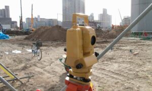 Total station surveying instrument on a tripod at a construction site for a construction staking survey.