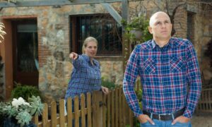 Neighbors arguing near a backyard fence during a property line survey dispute