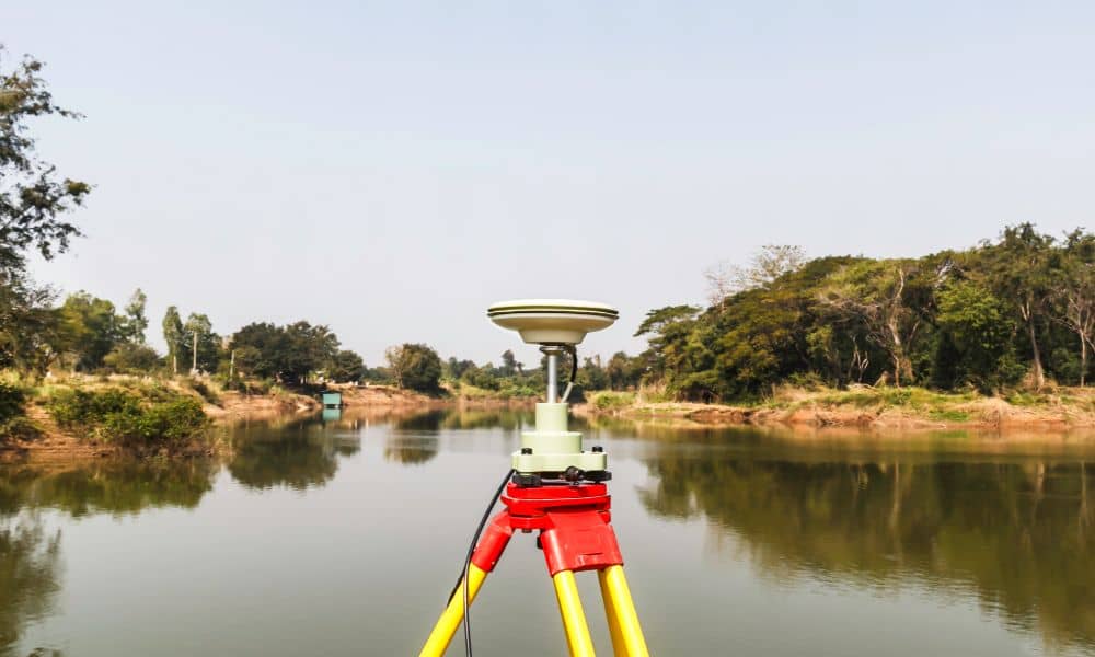 elevation certificate - Surveying equipment set up near a waterfront area to measure elevation for flood risk assessment in Boston