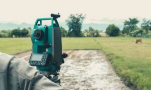 Professional lot survey in progress using modern equipment on an irregular residential property