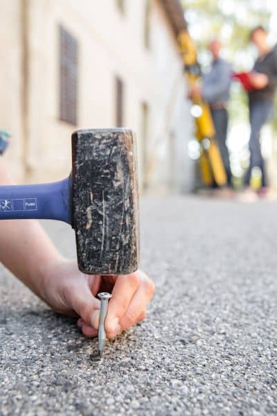 Surveyor marking a property line with a stake to confirm exact property boundaries